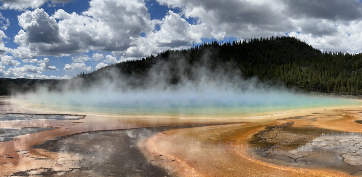 Ground view of Grand Prismatic Spring's vivid orange, yellow, and blue rings in Yellowstone's Midway Geyser Basin